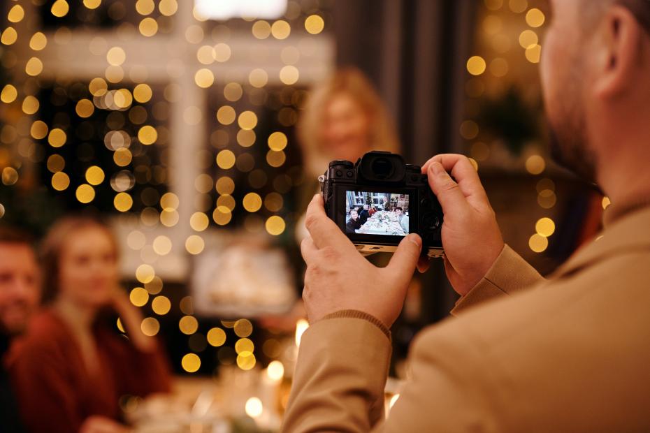 Mężczyzna fotografujący swoja rodzinę przy świątecznym stole